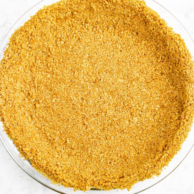 Overhead zoomed in view of a no-bake vegan graham cracker crust in a clear glass pie dish