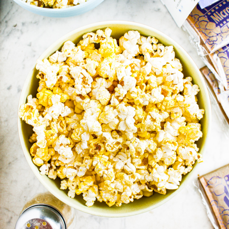 Overhead photo of two bowls of microwave popcorn with a blue box in the upper right corner