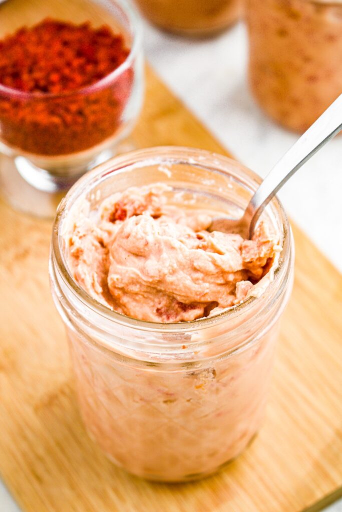 Overhead photo of a spoon digging into a jar of vegan cream of bacon substitute