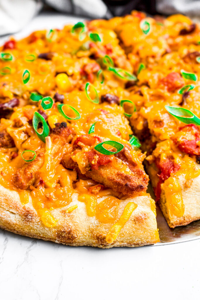 Head on view of a slice of leftover chili cheese fry pizza