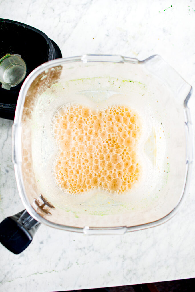 Overhead view of a creamy bubbly mixture in a blender