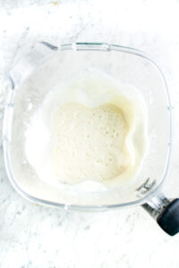 Overhead view of an open blender filled with creamy lemon mousse