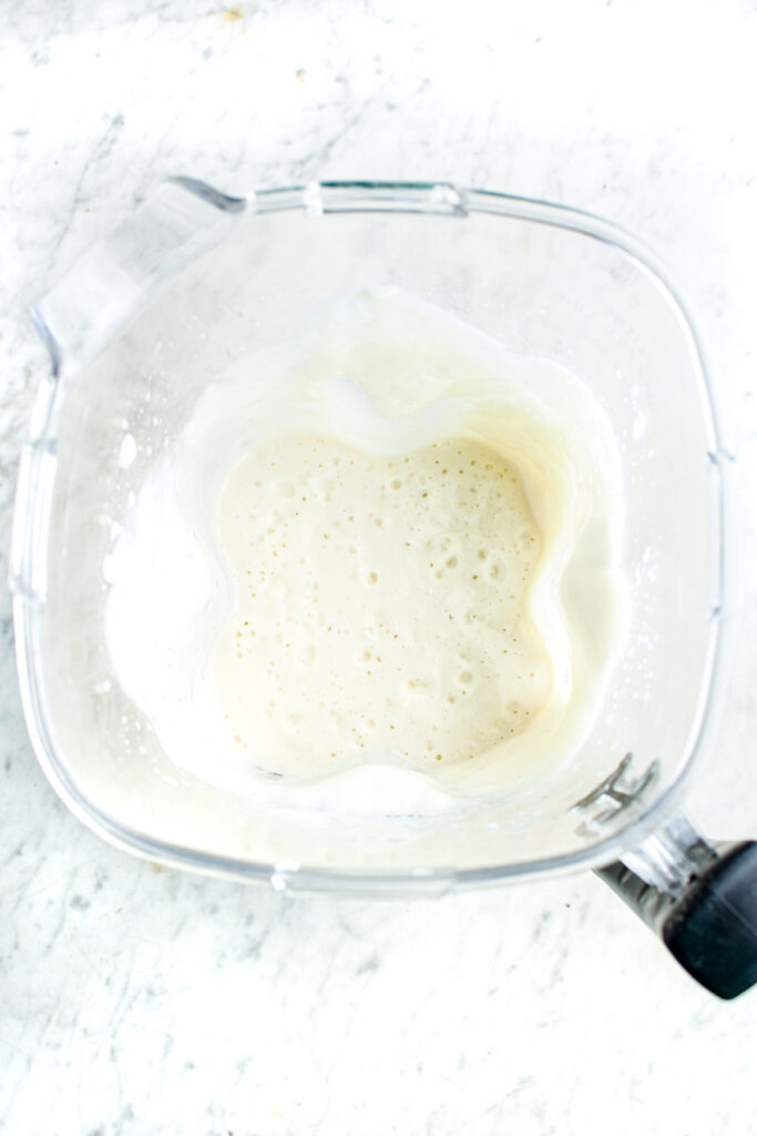 Overhead view of an open blender filled with creamy lemon mousse