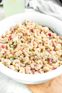 Overhead view of a round white bowl filled with deli-style vegan macaroni salad