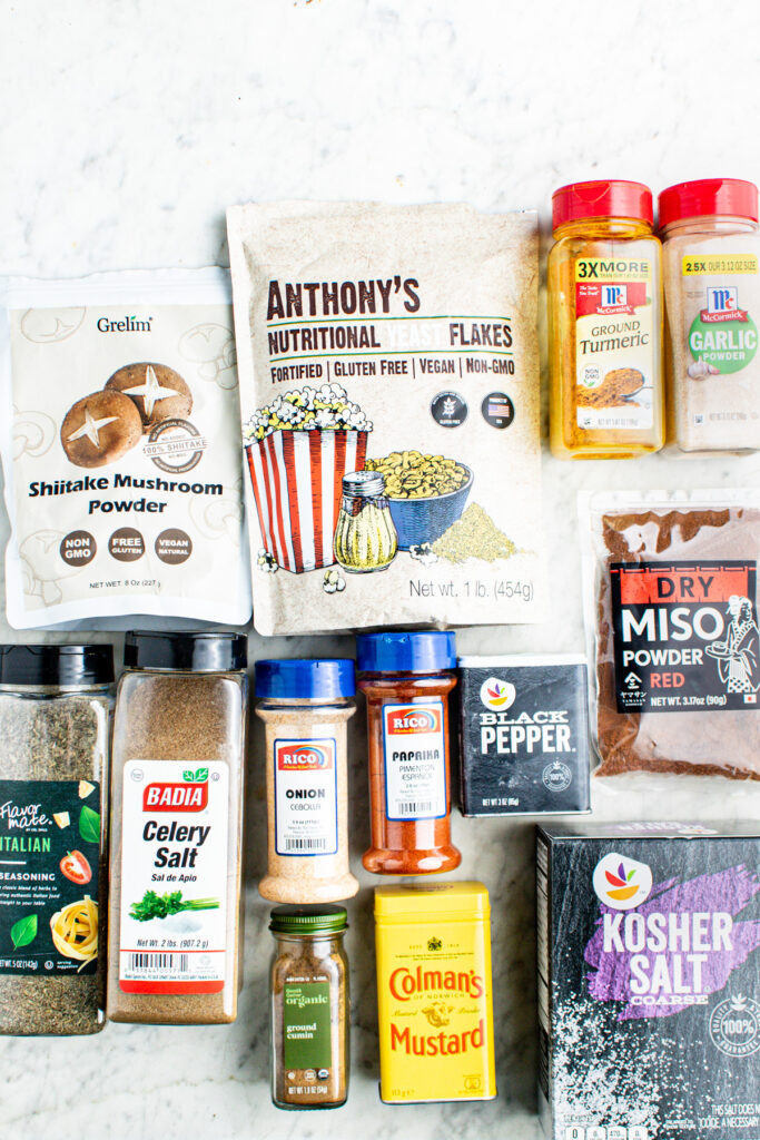Overhead view of all of the spices you need to make vegan beef bouillon powder on a grey marble countertop