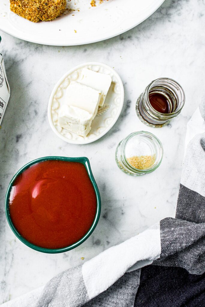 Overhead view of all the ingredients you need to make vegan buffalo sauce on a marble countertop