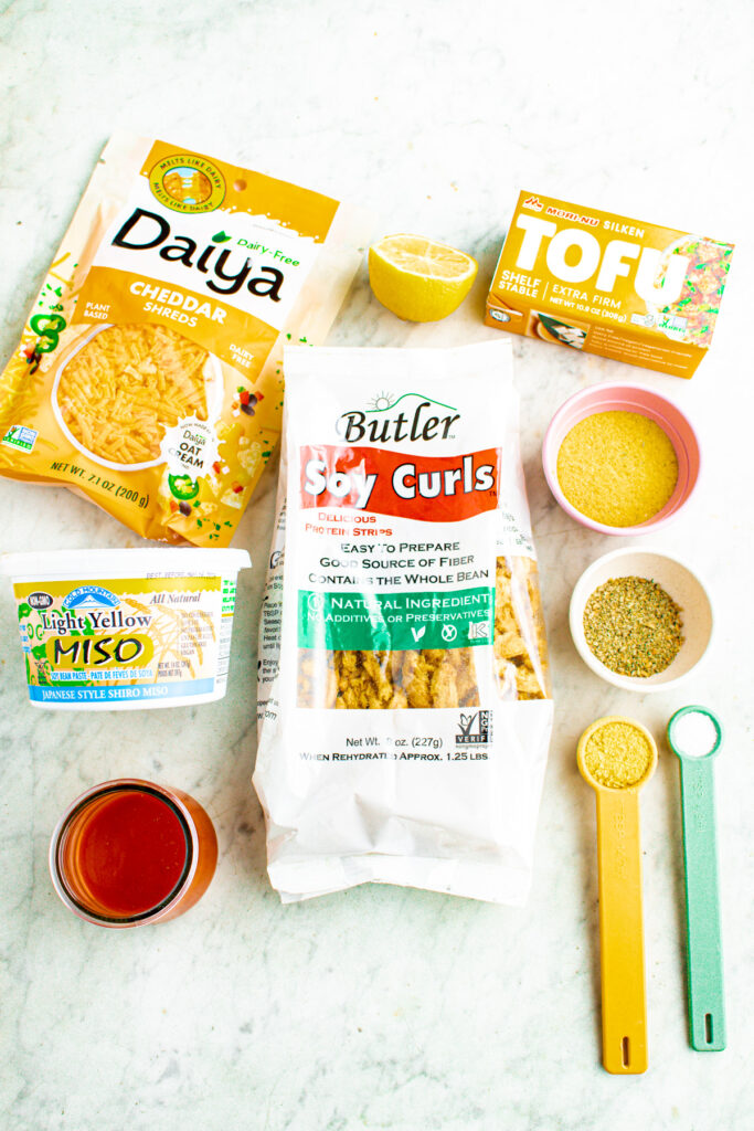 An overhead view of all the ingredients you need to make vegan buffalo chicken dip laid out on a grey marble countertop