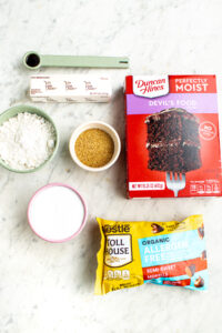 Overhead view of all the ingredients you need to make vegan chocolate cookies with cake mix laid out on a grey marble countertop